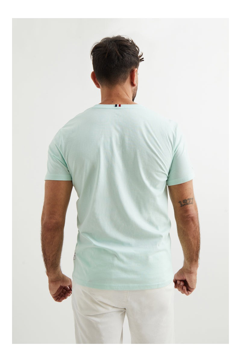  Camiseta turquesa con logo bordado en rojo tipo parche. Color y estilo para tu día a día. 