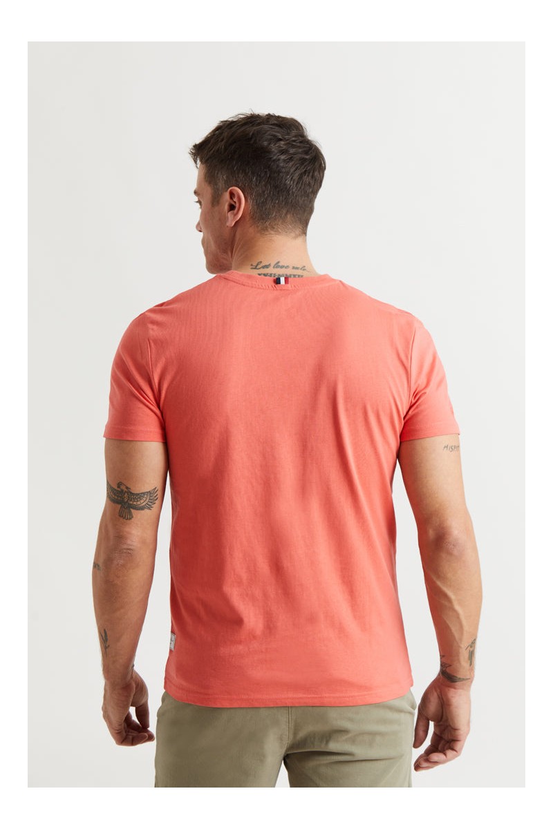  Camiseta coral con logo bordado en rojo tipo parche. Comodidad y estilo con un color vibrante. 
