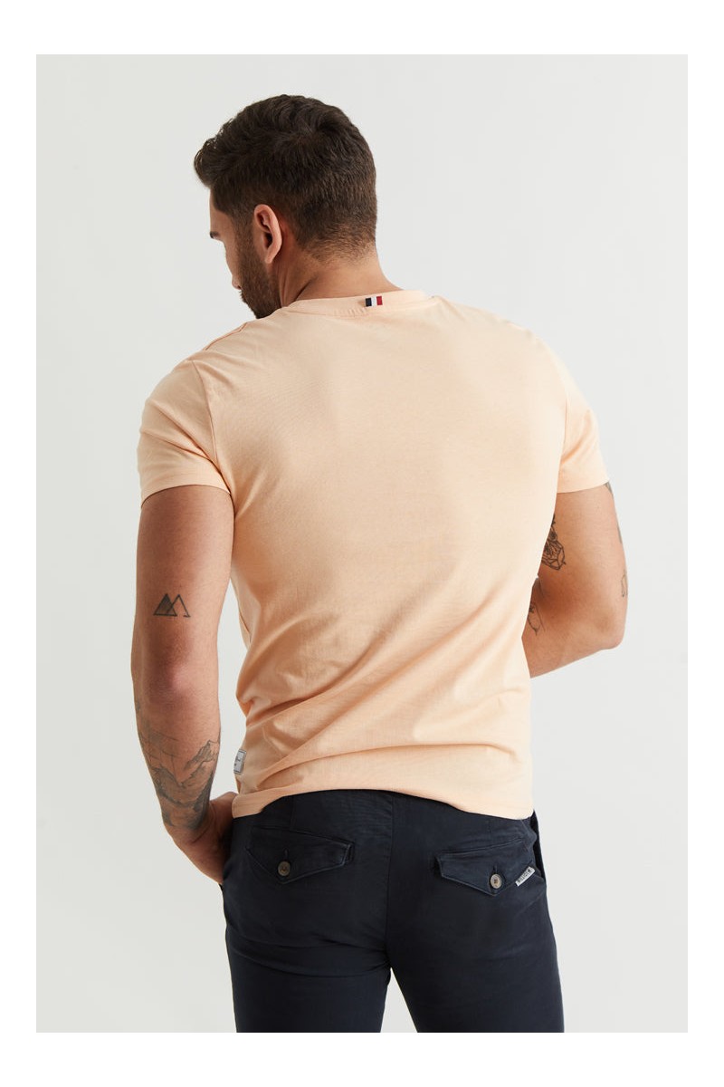  Camiseta naranja Williot con logo bordado en rojo tipo parche. Estilo moderno con mucho carácter. 