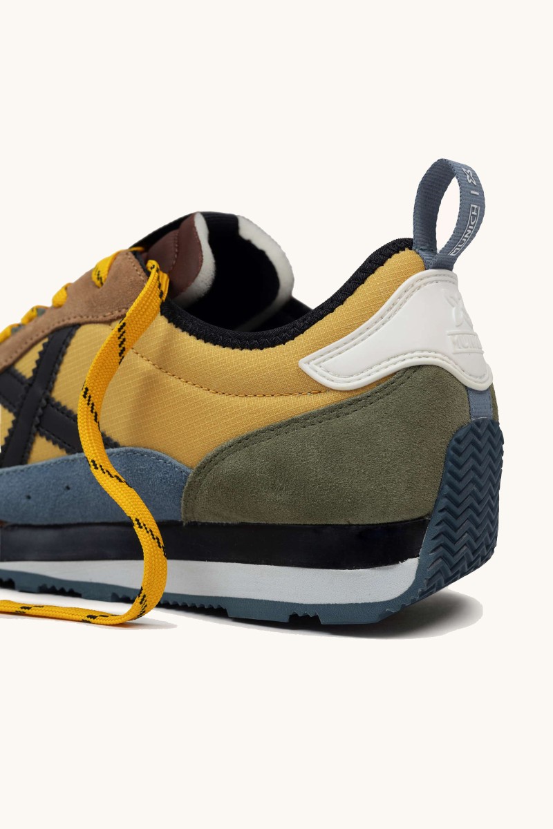  Zapatilla de Munich con diseño setentero, perfil bajo y estilo urbano. Perfecta para looks casuales con identidad. 