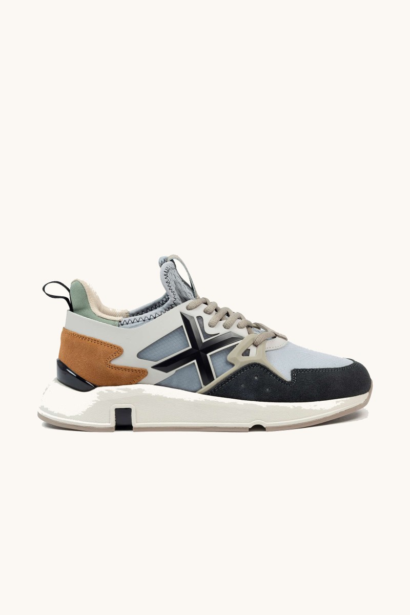Zapatilla de Munich con diseño innovador, mezcla de materiales y un estilo que fusiona herencia deportiva y tendencia.