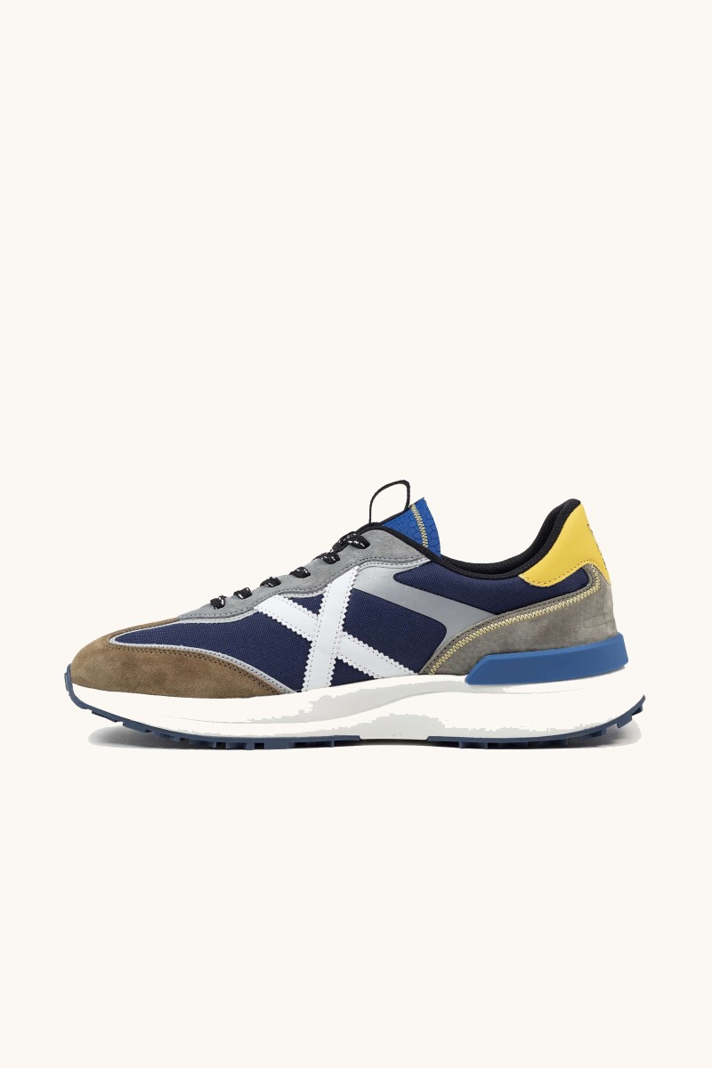  Zapatilla de Munich con diseño urbano, mezcla de materiales y estructura cómoda pensada para uso diario. 