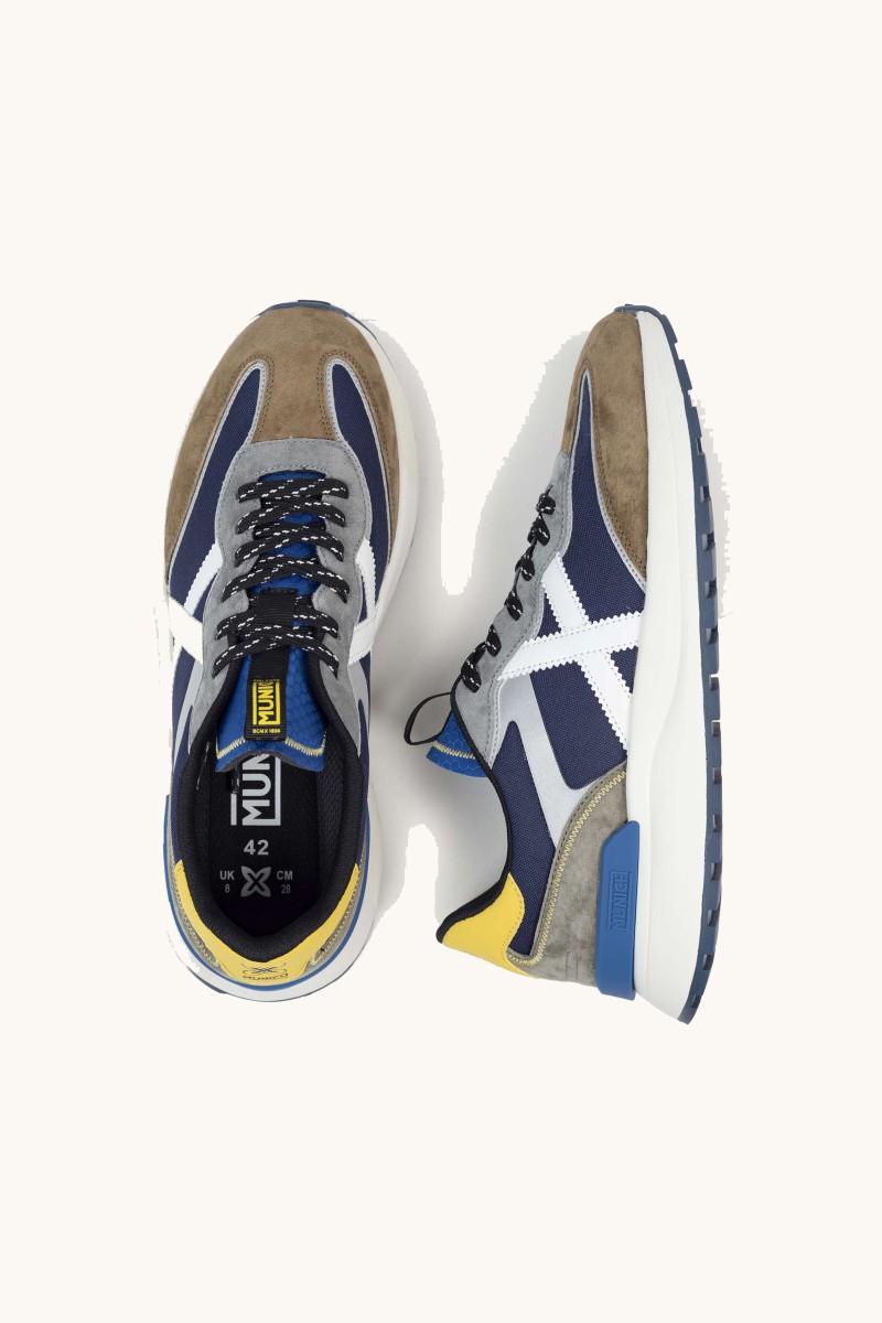  Zapatilla de Munich con diseño urbano, mezcla de materiales y estructura cómoda pensada para uso diario. 