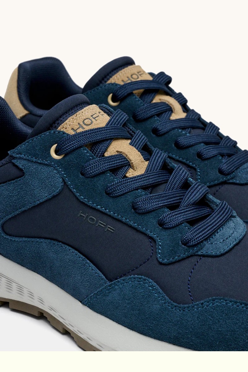  Zapatilla de HOFF en tono navy, diseño combinando materiales, con suela tipo waffle que aporta tracción y estilo urbano. 
