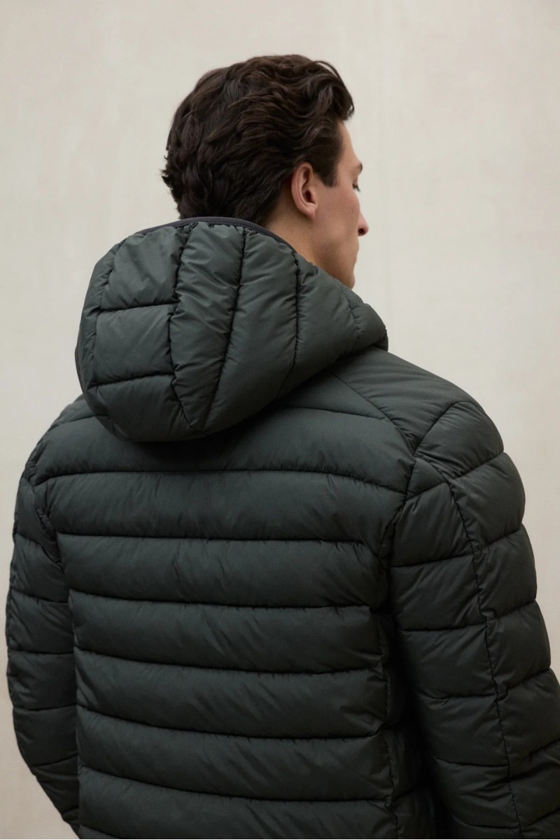  Chaqueta acolchada en tono Beetle, con capucha ajustable y diseño pensado para ofrecer abrigo ligero en ambientes urbanos. 