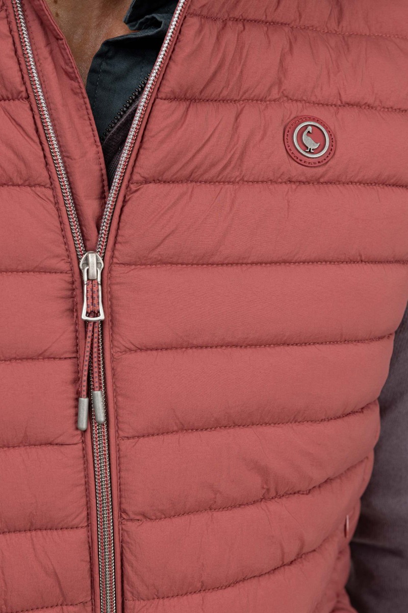  Chaleco ligero acolchado en color rojo, con diseño moderno y corte estilizado, ideal para capas intermedias con estilo urbano. 