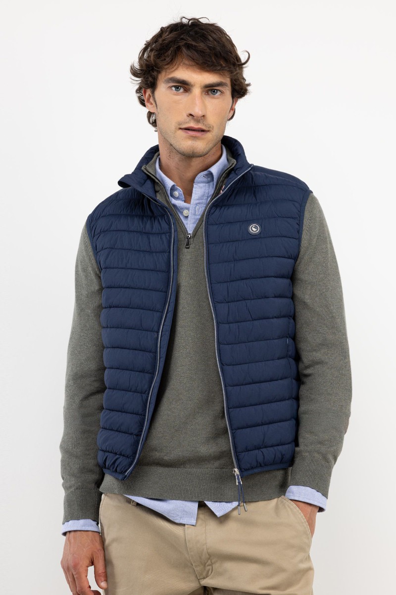  Chaleco acolchado en azul marino, con diseño minimalista y estructura ligera ideal para añadir una capa extra sin perder estilo. 