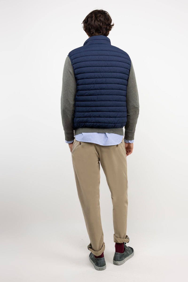  Chaleco acolchado en azul marino, con diseño minimalista y estructura ligera ideal para añadir una capa extra sin perder estilo. 