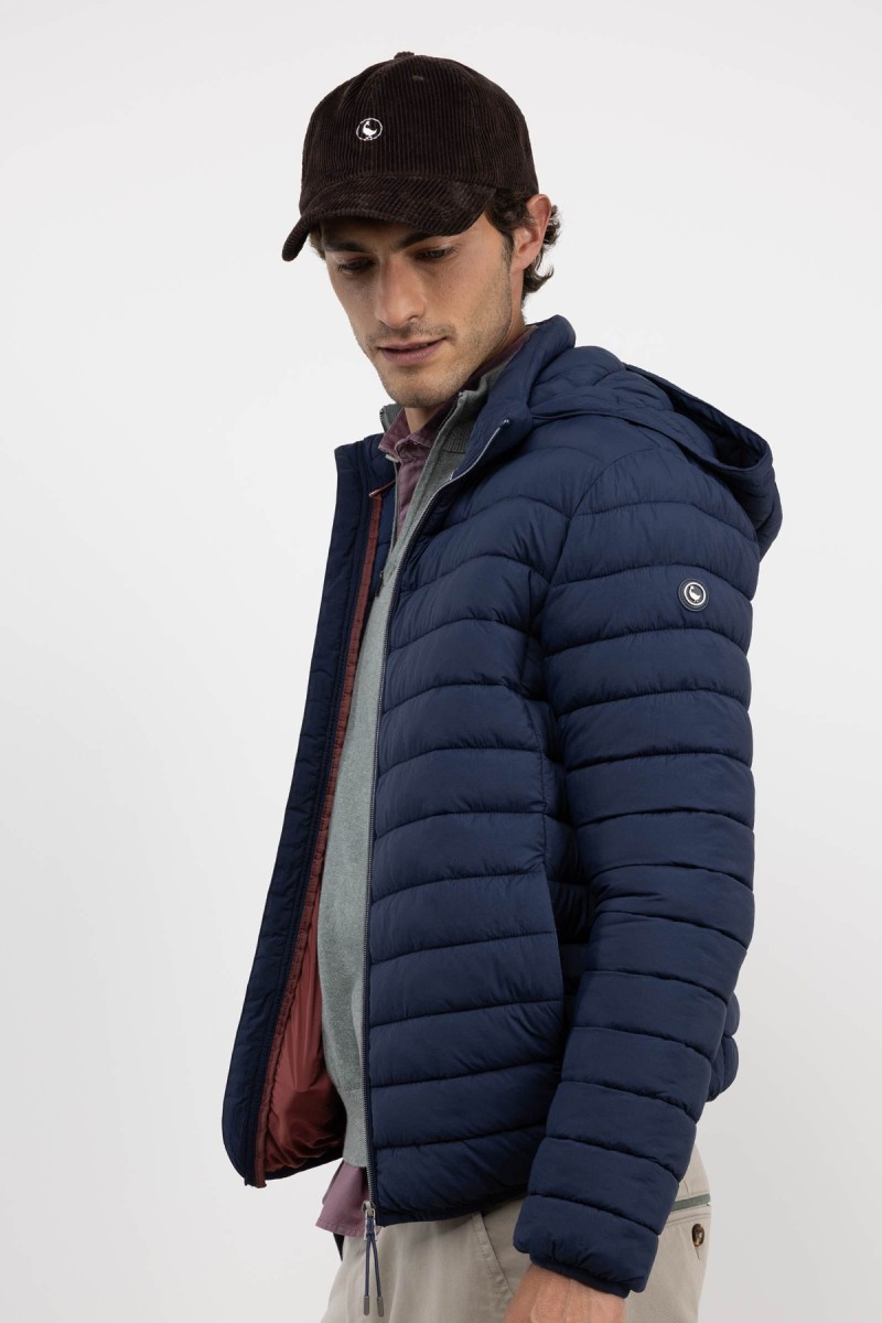  Chaqueta acolchada en tono marino con diseño sencillo y estructura ligera, ideal para aportar abrigo sin excederse. 