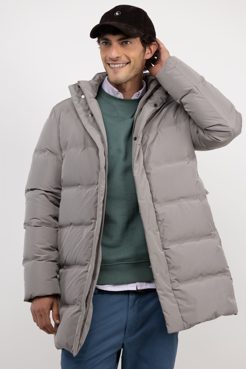  Abrigo largo acolchado en beige, diseño envolvente y funcionalidad térmica para afrontar el frío con estilo. 