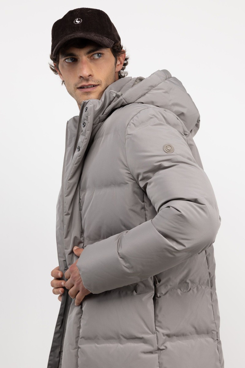  Abrigo largo acolchado en beige, diseño envolvente y funcionalidad térmica para afrontar el frío con estilo. 