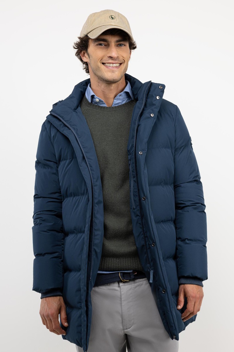  Abrigo largo acolchado en azul, con diseño envolvente y estilo sobrio para enfrentar el frío con elegancia. 