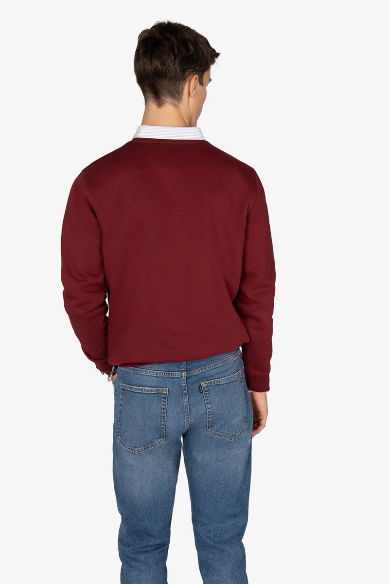  Sudadera estilo “college” en tono burdeos, con textura suave, cuello reforzado y diseño gráfico emblemático. 