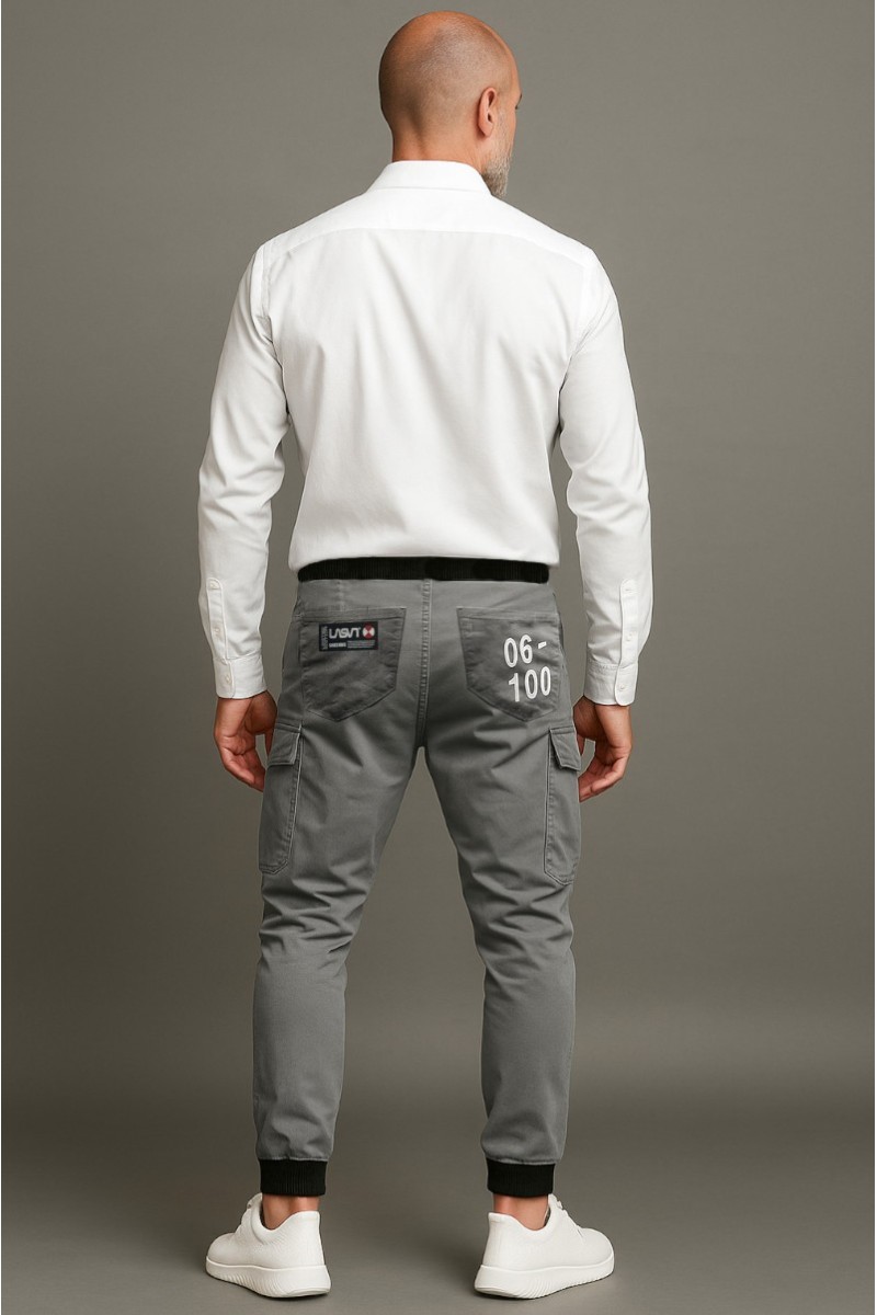 Jogger cargo en tono gris confeccionado en sarga elástica con bolsillos utilitarios, diseño urbano y numeración de edición limitada.