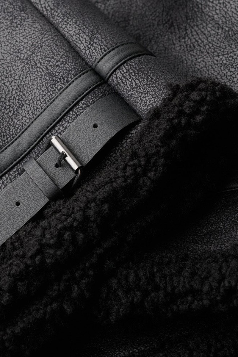  Chaqueta estilo aviador confeccionada en piel vegana con interior de borreguito, ideal para un look moderno y con carácter. 