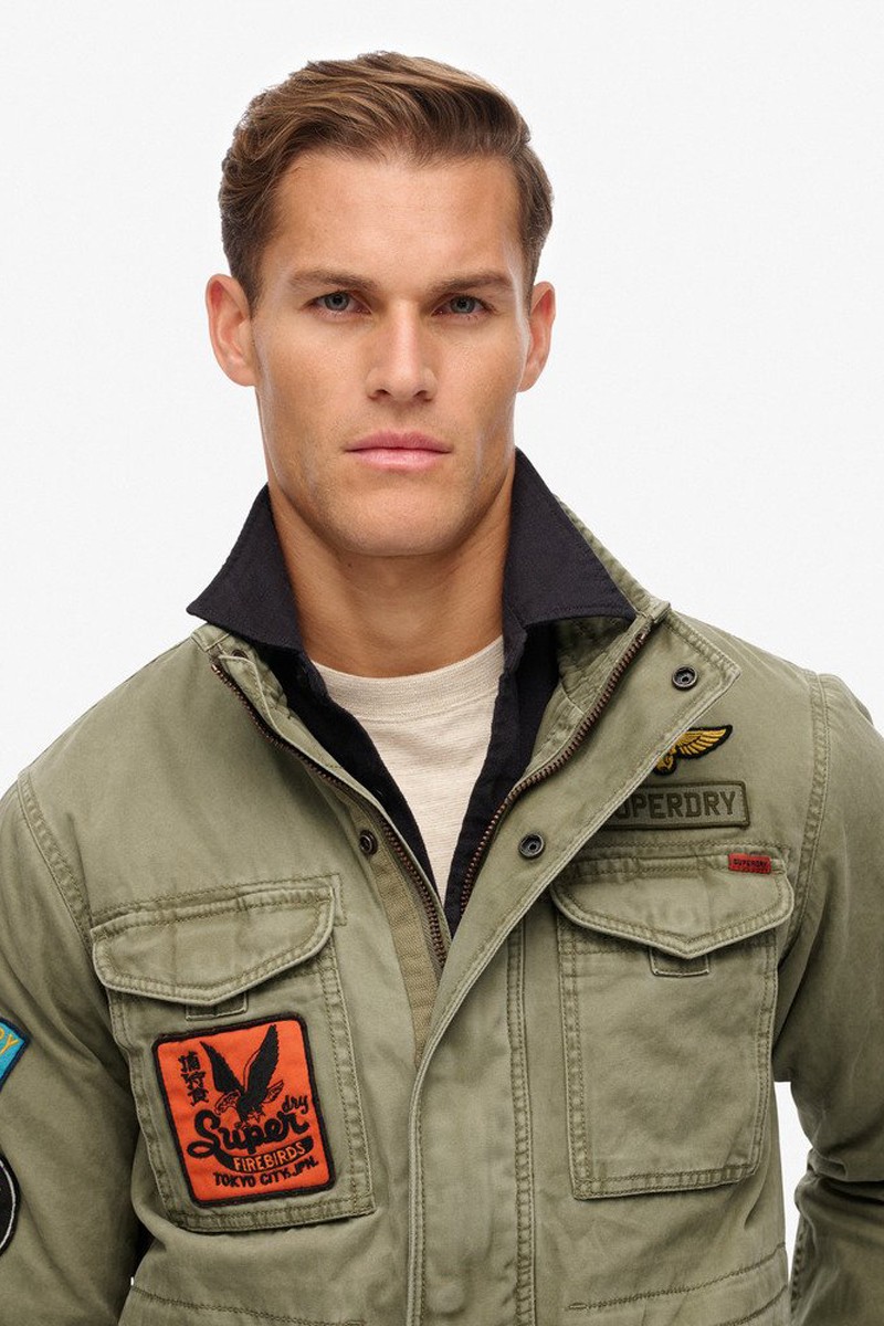  Chaqueta estilo militar con parches decorativos, múltiples bolsillos y cierre de cremallera y botones para un look auténtico y versátil. 