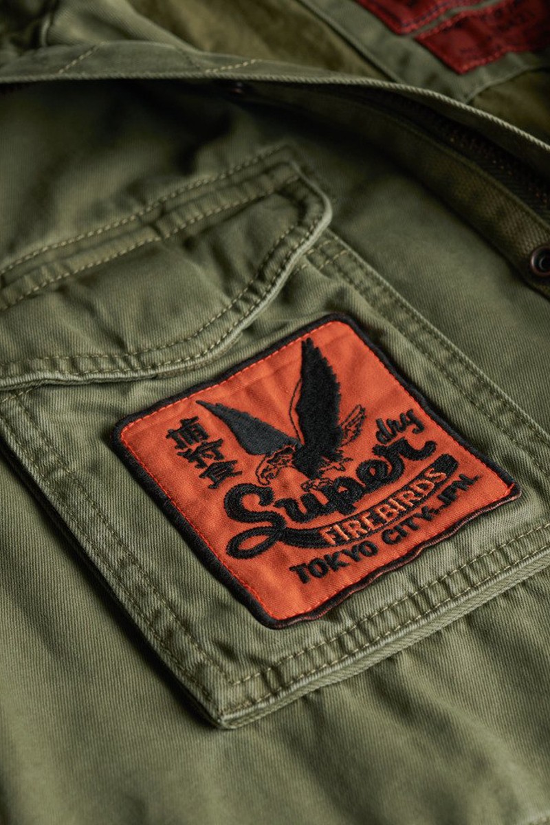  Chaqueta estilo militar con parches decorativos, múltiples bolsillos y cierre de cremallera y botones para un look auténtico y versátil. 