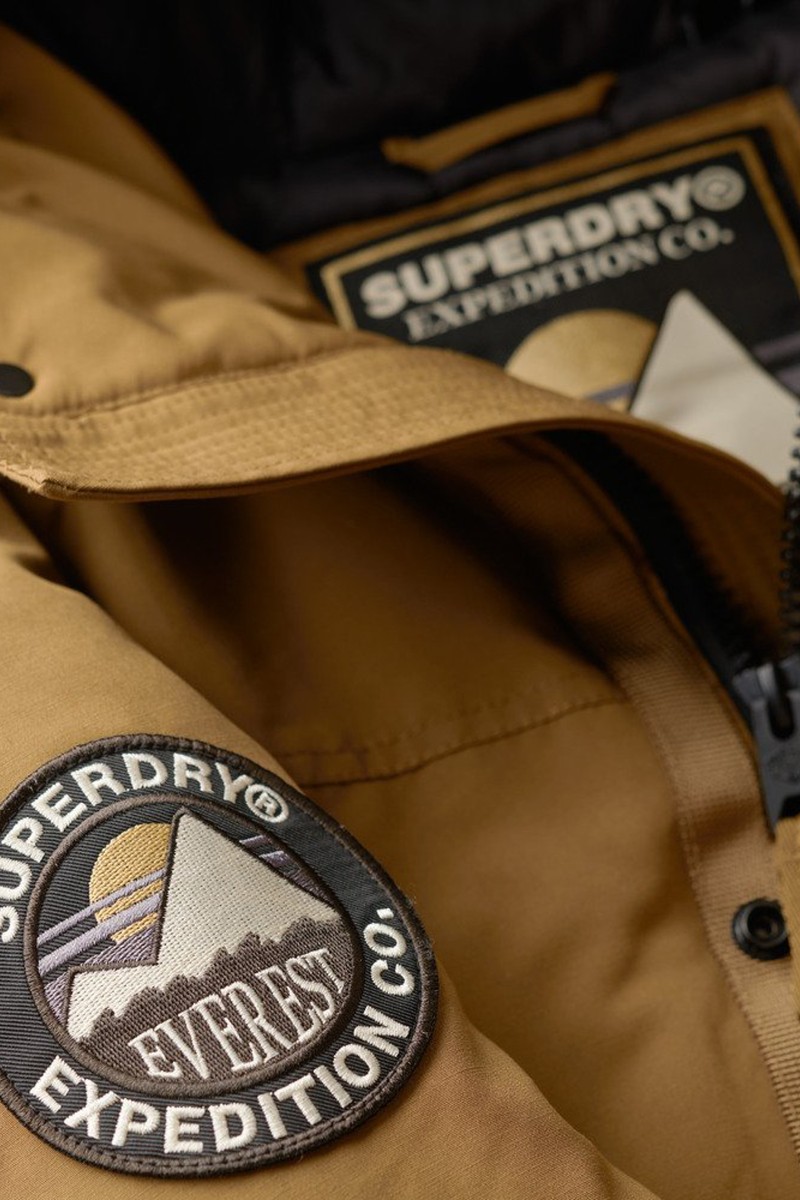  Parka acolchada con capucha y borde de pelo sintético, perfecta para mantener el calor sin perder estilo. 