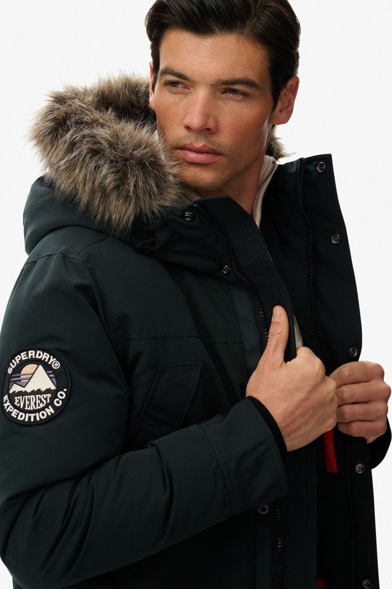  Parka acolchada con capucha y borde de pelo sintético, perfecta para mantener el calor sin perder estilo.  2