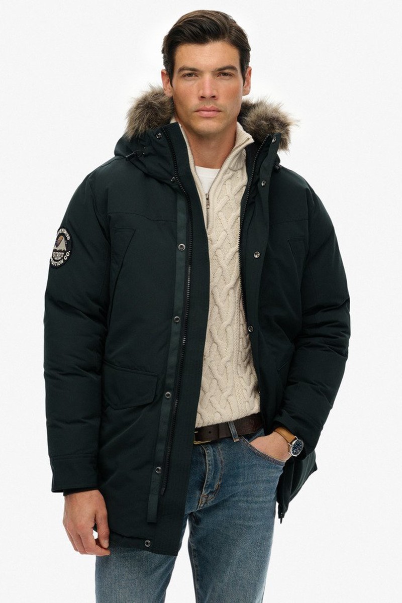  Parka acolchada con capucha y borde de pelo sintético, perfecta para mantener el calor sin perder estilo. 