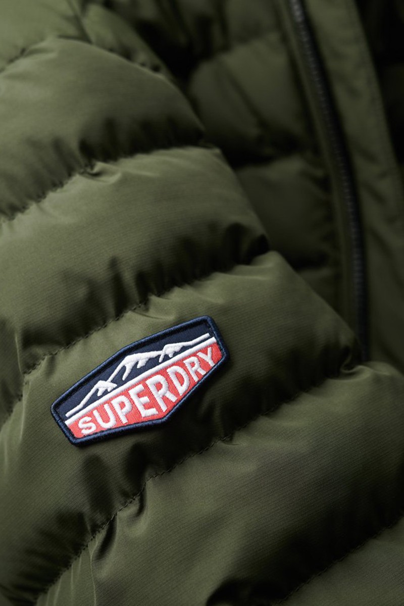  Chaqueta acolchada ligera con cierre de cremallera y cuello alto, ideal para el día a día con el estilo inconfundible de Superdry. 