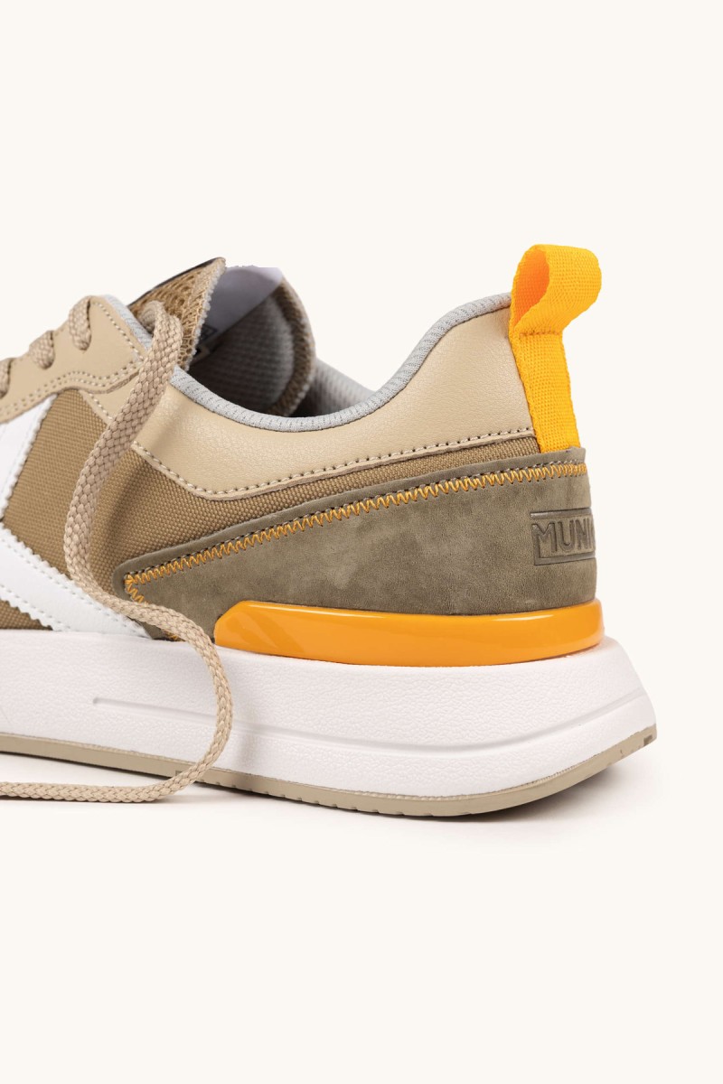  Zapatillas Munich en tonos tierra con detalles en mostaza, perfectas para looks urbanos versátiles y cómodos en el día a día. 