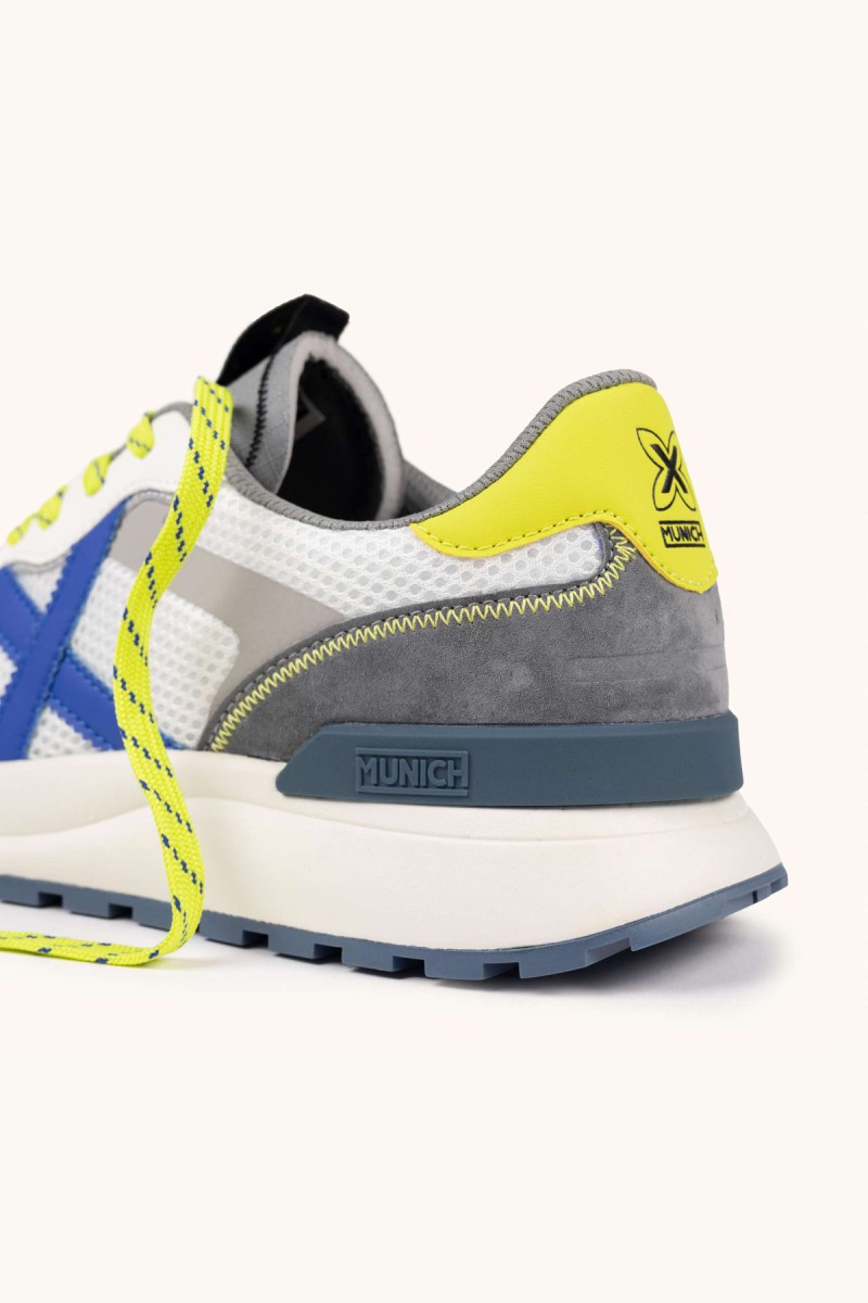  Zapatillas Munich en blanco y gris con detalles flúor, ideales para looks urbanos modernos con comodidad y estilo diario. 