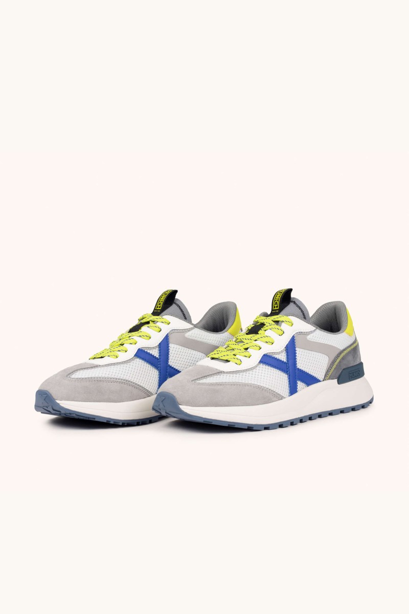  Zapatillas Munich en blanco y gris con detalles flúor, ideales para looks urbanos modernos con comodidad y estilo diario. 