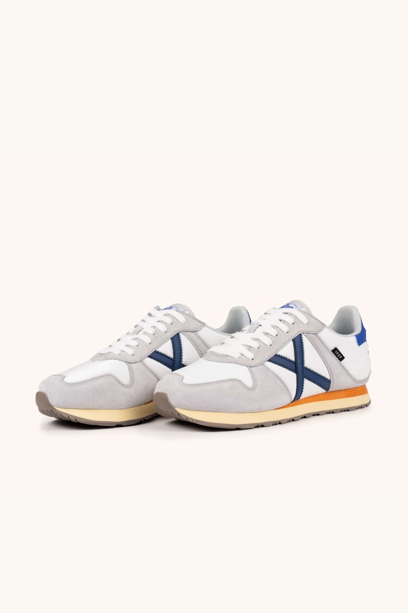  Zapatillas Munich en blanco y gris con estilo retro running, ideales para looks urbanos cómodos y versátiles. 