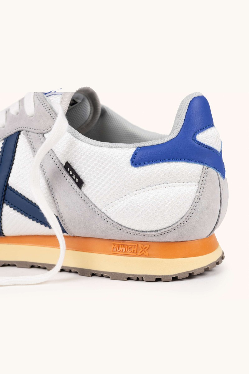  Zapatillas Munich en blanco y gris con estilo retro running, ideales para looks urbanos cómodos y versátiles. 