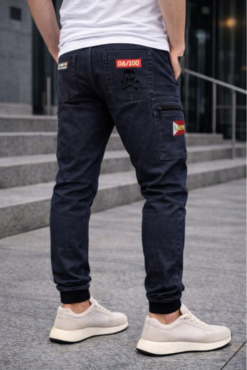  Pantalón cargo jogger La Sal en sarga elástica de 280gr, con cintura y tobillos elásticos y bolsillos con cremallera. Diseñado en España, hecho en Portugal y limitado a solo 100 unidades numeradas. 