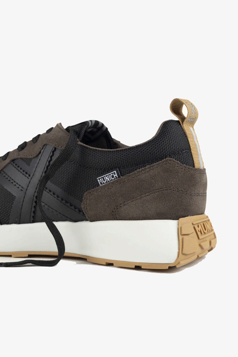  Zapatillas Munich de inspiración retro running que combinan elegancia deportiva y estética urbana. Su mezcla de negro, marrón oscuro, blanco y suela color caramelo crea un diseño atemporal y fácil de combinar.  2