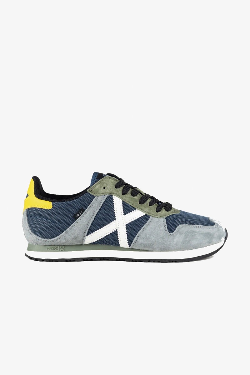  Zapatillas Munich de inspiración retro running que recuperan una silueta histórica de la marca. Su combinación de gris claro, azul petróleo y amarillo aporta un estilo deportivo y urbano con personalidad. 