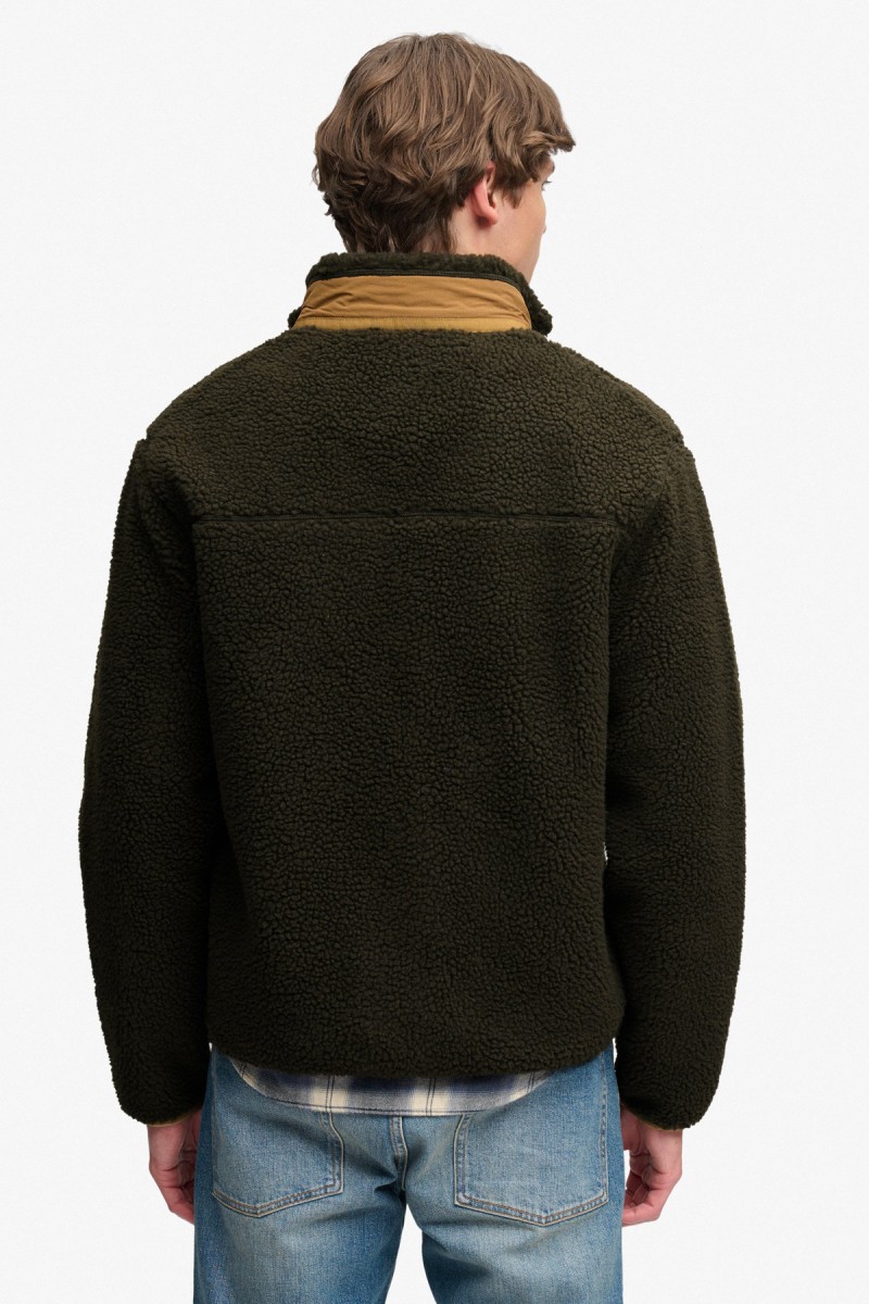  Forro polar Superdry para hombre con diseño de inspiración retro, corte Relaxed Fit y cierre completo de cremallera. Una prenda versátil para el entretiempo con cuello alto y tres bolsillos exteriores. 