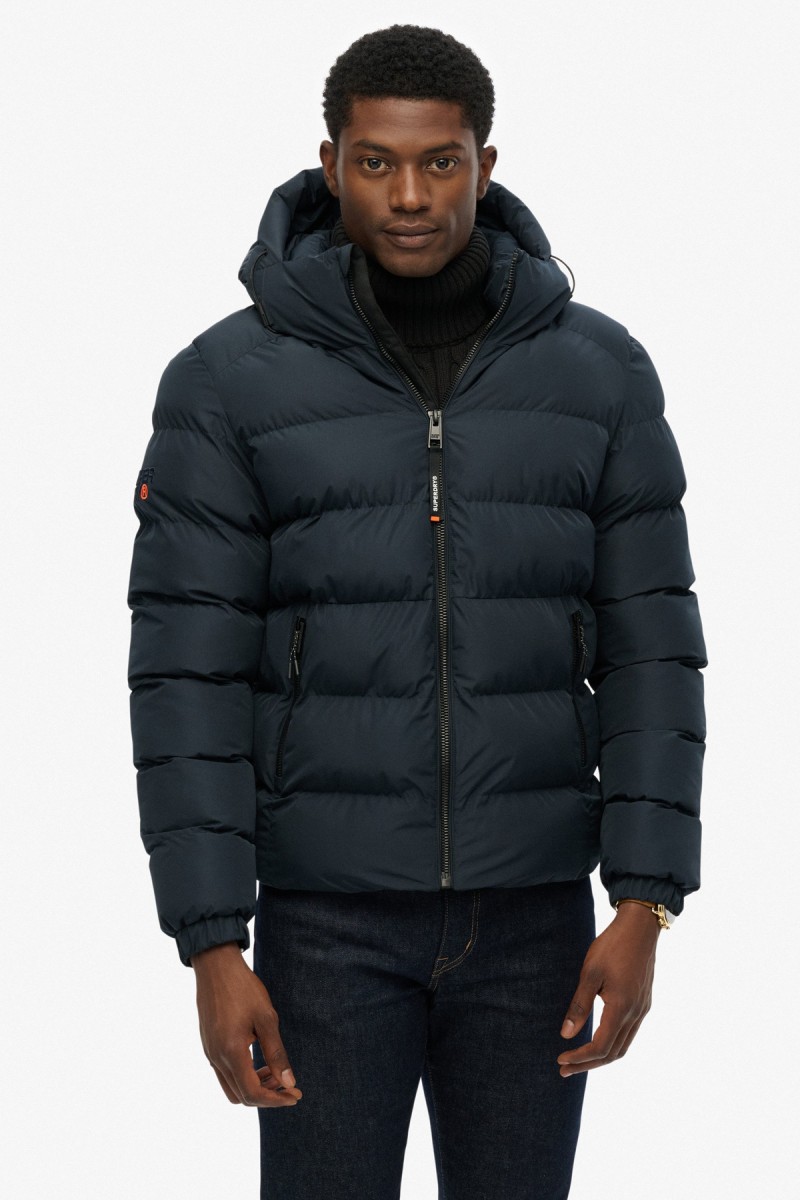  Cazadora acolchada Superdry para hombre con corte Relaxed Fit, capucha ajustable y acabado repelente al agua. Un diseño deportivo y urbano pensado para aportar abrigo y comodidad durante los meses más fríos. 