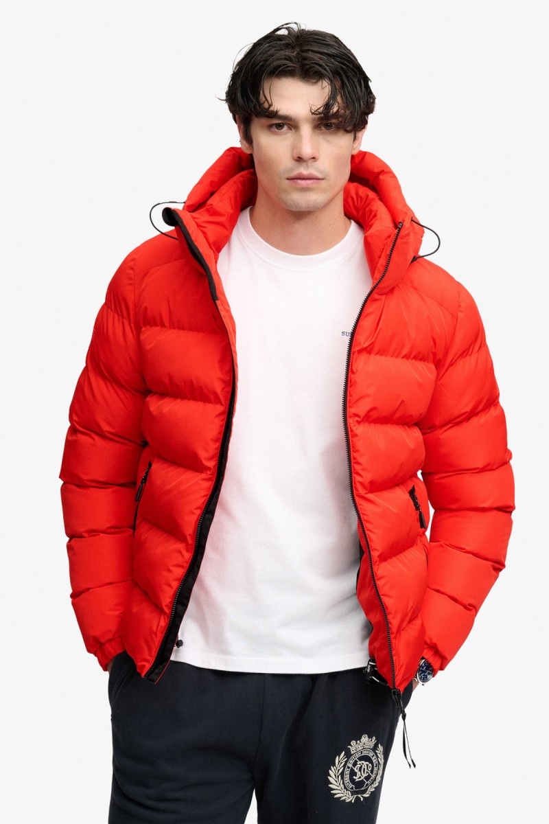  Cazadora acolchada Superdry para hombre con corte Relaxed Fit, capucha ajustable y acabado repelente al agua. Un diseño deportivo y urbano pensado para aportar abrigo y comodidad durante los meses más fríos. 