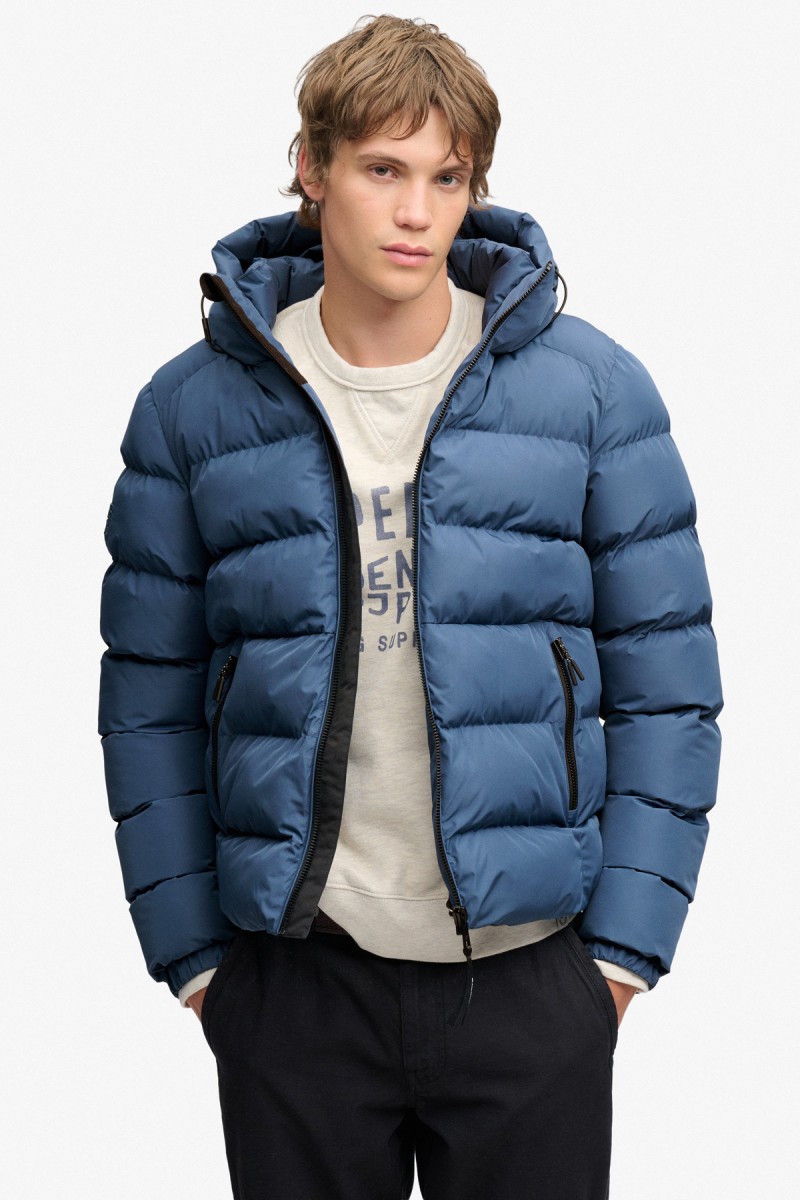  Cazadora acolchada Superdry para hombre con corte Relaxed Fit, capucha ajustable y acabado repelente al agua. Un diseño deportivo y urbano pensado para aportar abrigo y comodidad durante los meses más fríos. 