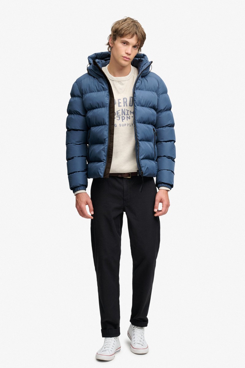  Cazadora acolchada Superdry para hombre con corte Relaxed Fit, capucha ajustable y acabado repelente al agua. Un diseño deportivo y urbano pensado para aportar abrigo y comodidad durante los meses más fríos.  2