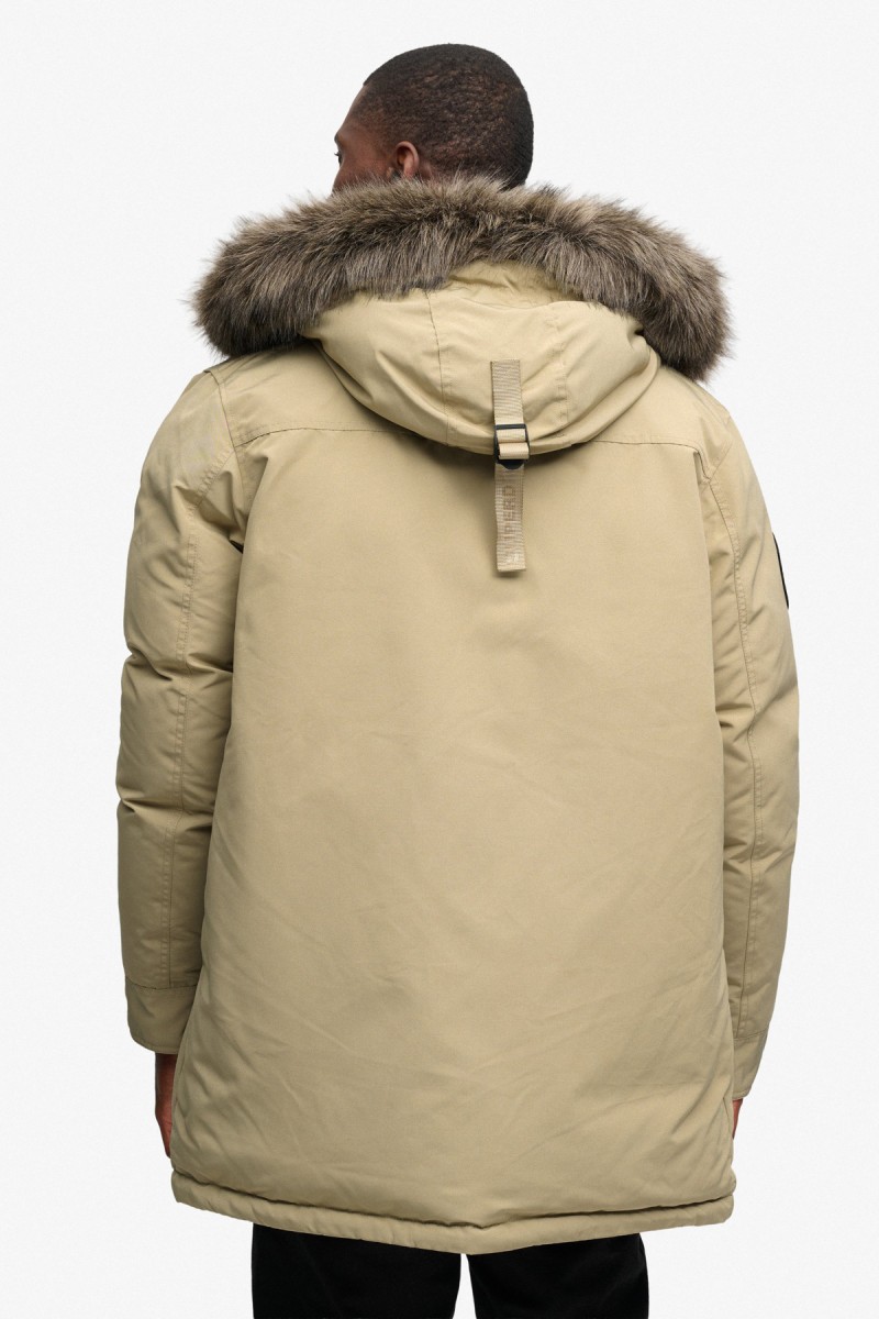  Parka Superdry acolchada para hombre con diseño largo, corte Loose Fit y capucha con pelo sintético desmontable. Una prenda cálida y funcional con acabado repelente al agua, perfecta para los meses más fríos. 