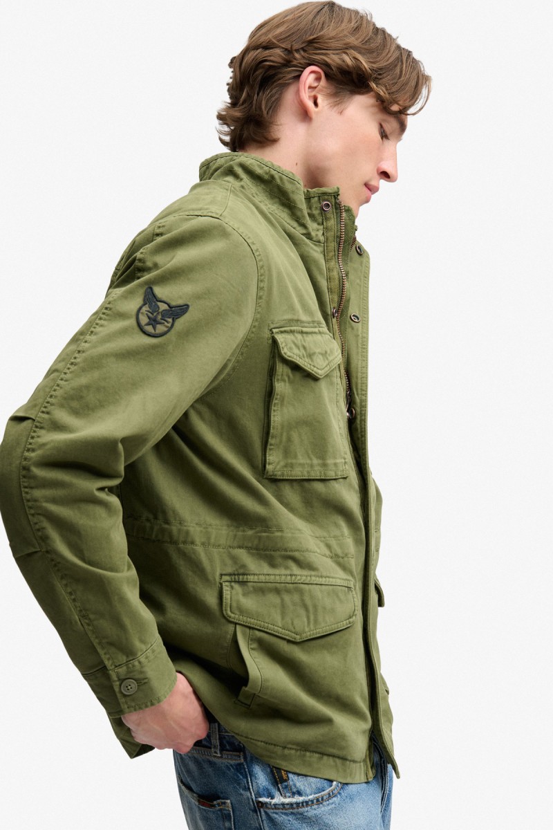  Cazadora Superdry para hombre inspirada en la clásica chaqueta militar M65, confeccionada en algodón y con corte Relaxed Fit. Sus múltiples bolsillos, cuello alto y detalles de inspiración vintage aportan un marcado carácter utilitario. 