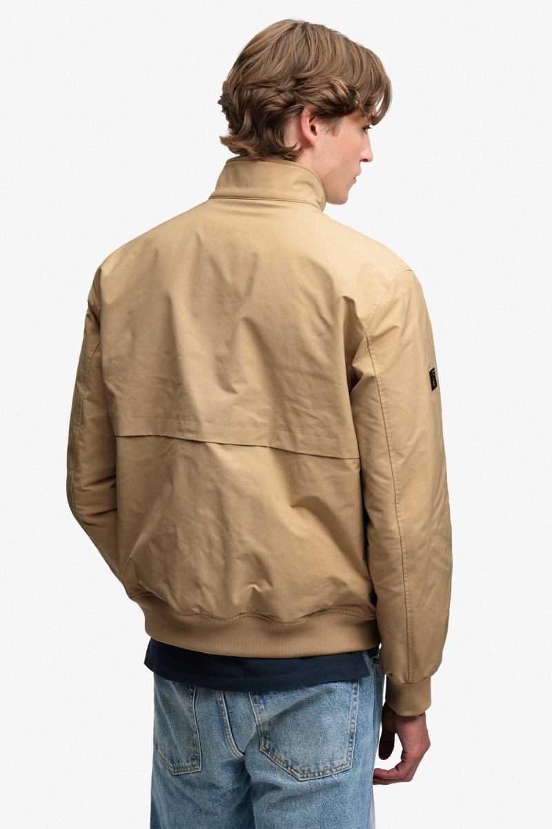  Cazadora Superdry para hombre de estilo Harrington con diseño acolchado y corte Relaxed Fit. Una reinterpretación premium de un clásico, con líneas limpias, acabados de canalé y una estética elegante y versátil. 
